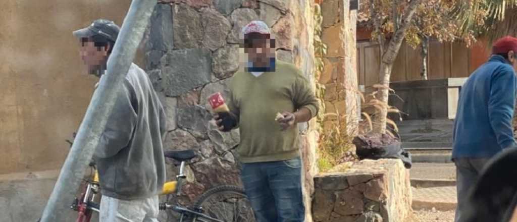 Trabajadores tomando del pico de una botella en Godoy Cruz